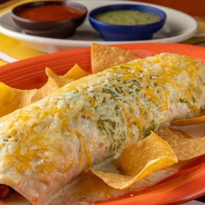 Super Burrito covered in cheese, with tortilla chips and salsas.