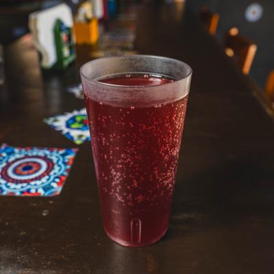 Glass of Aguas Fresca served on a bar counter.