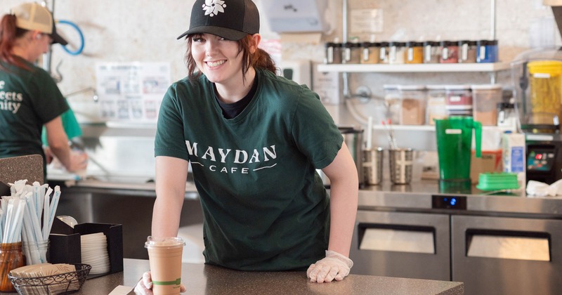Barista presenting a cup of coffee on the counter
