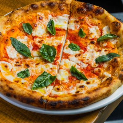 Handcrafted Margherita pizza topped with basil and cheese.