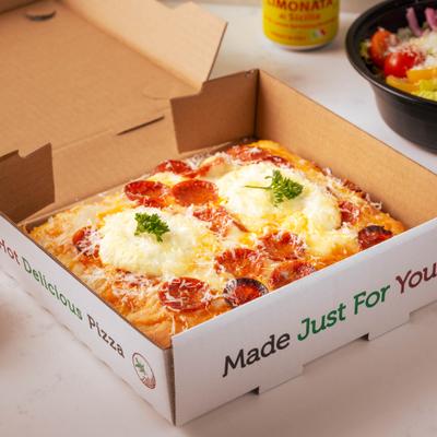 A rectangular pepperoni pizza with melted cheese inside a small cardboard box.