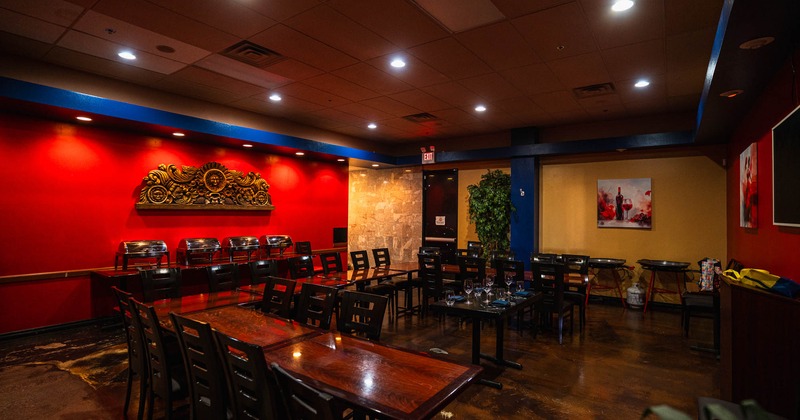 Restaurant dining room with red walls, wooden tables and chairs