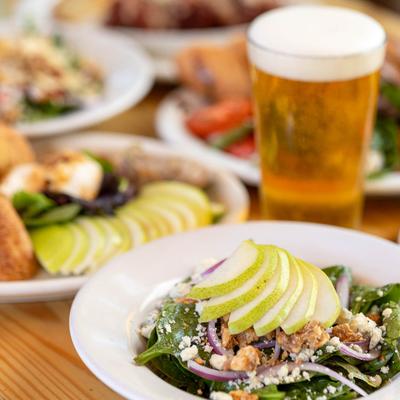 Pear-gorgonzola salad served with a glass of beer.