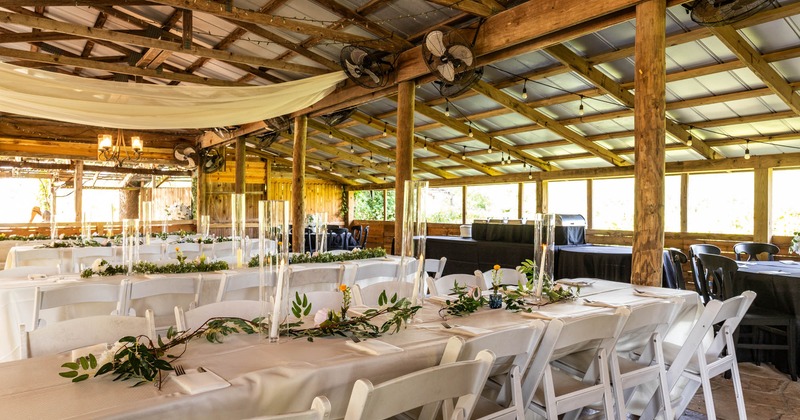 Wedding venue, wedding decorated white cloth tables, exposed wooden beams