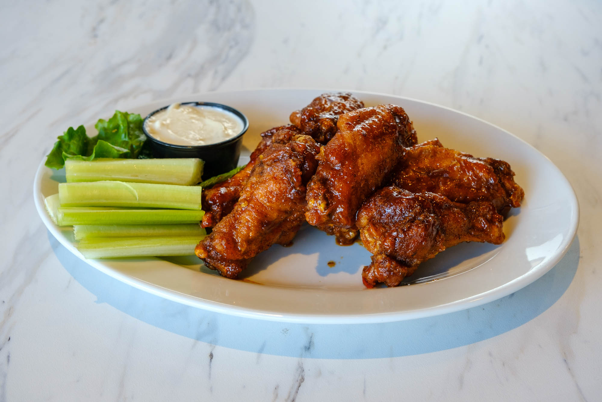 Chicken wings, served with celery, and ranch dressing