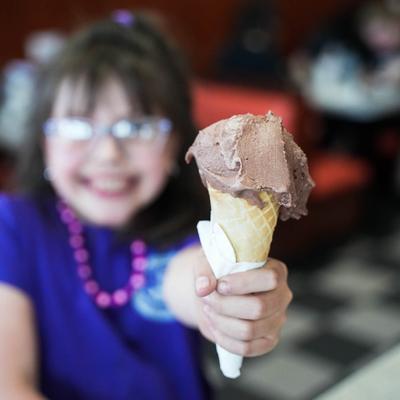 A child holding a chocolate ice cream.