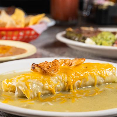 Shrimp Enchilada topped with shrimp and covered in a green tomatillo sauce.