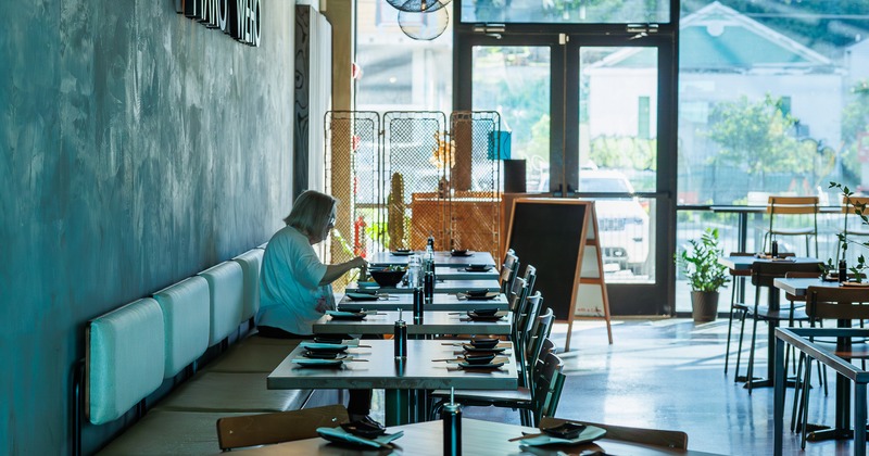 Interior, tables, chairs, guests, entrance behind