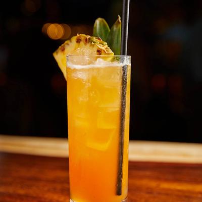 Orange cocktail with pineapple garnish.