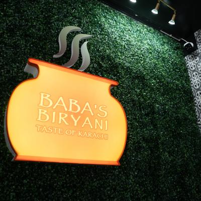 Restaurant 3D logo on a green wall.