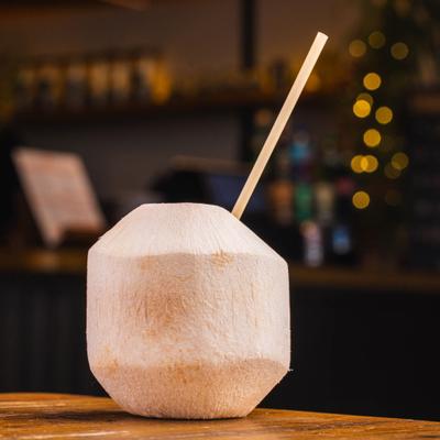 Fresh Coconut Water served in a young coconut with a straw.