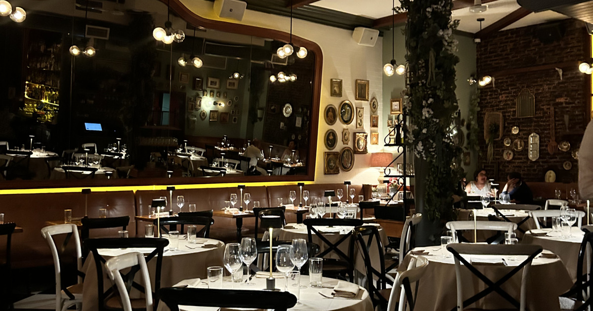 Elegant restaurant dining room with round tables, wine glasses, and warm lighting