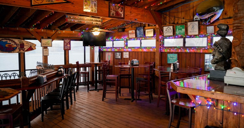 Interior, wooden walls, floor and ceiling, bar stools and tables, poster decorated walls