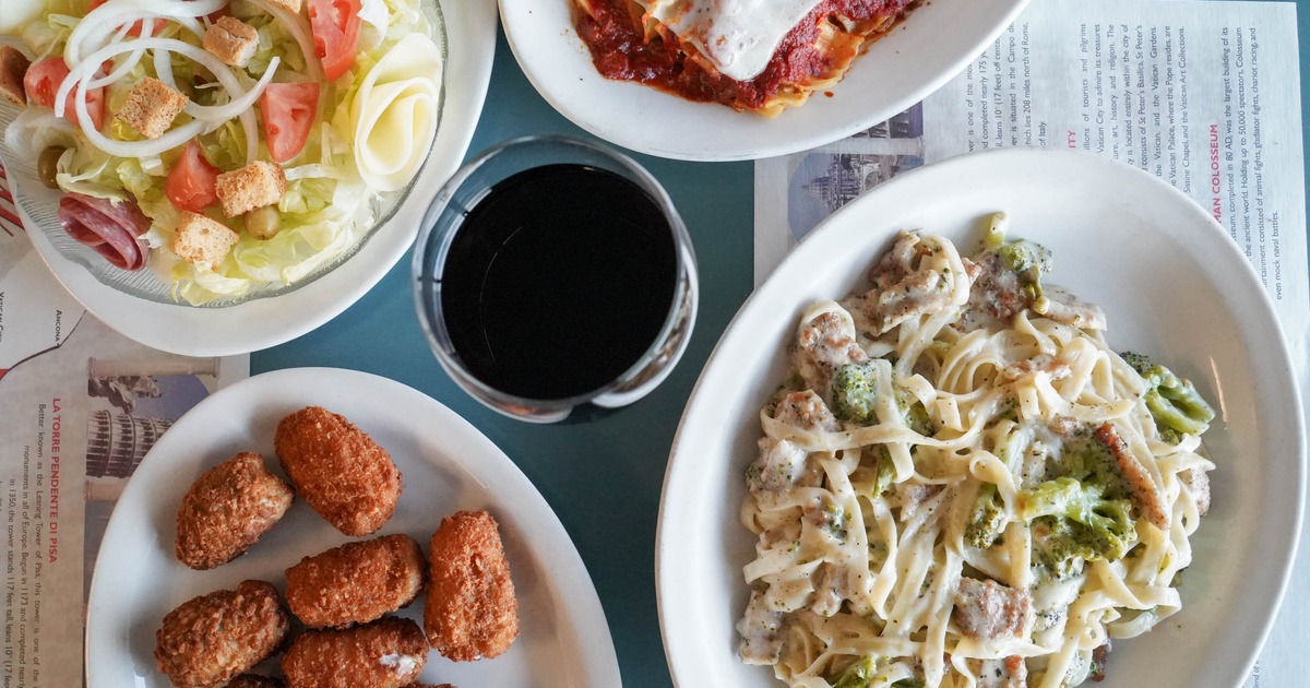 Italian meal with pasta, lasagna, salad, and jalapeno poppers