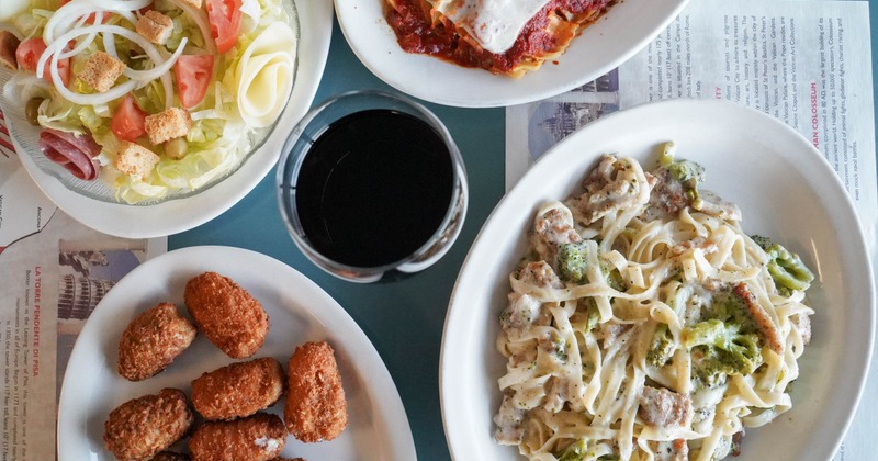 Italian meal with pasta, lasagna, salad, and jalapeno poppers