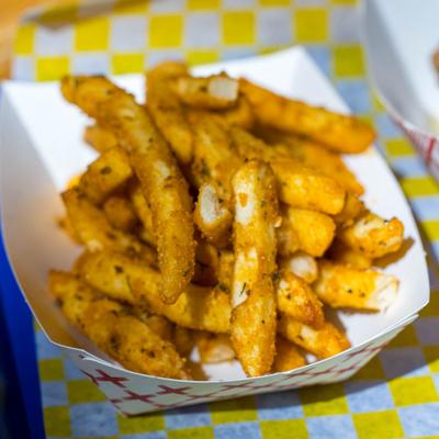 Seasoned fries in a paper tray.
