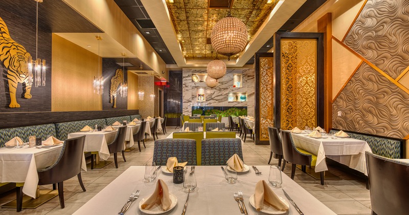 Interior of spacious and cozy dining area with dining tables set for guests