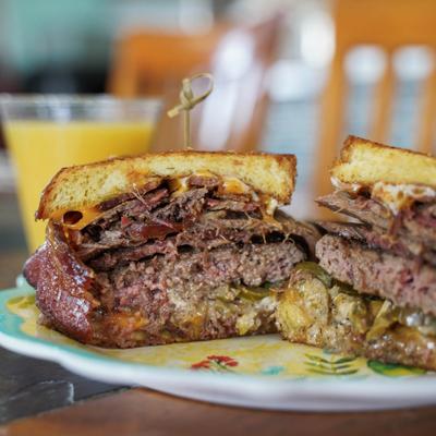 Chez Special burger with  grilled cheese, burger patty, smoked beef brisket, and jalapenos.