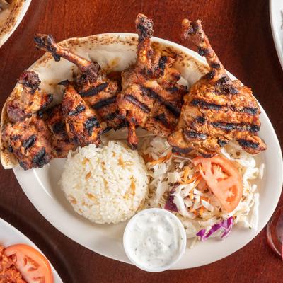 Mediterranean grilled lamb chops with rice, slaw, and sauce.