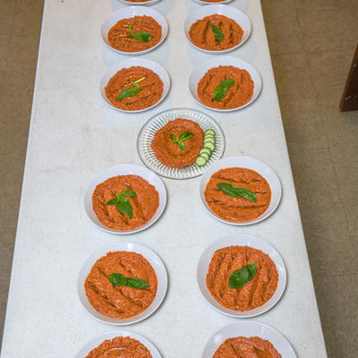 Full table of plates with red sauce and cucumbers