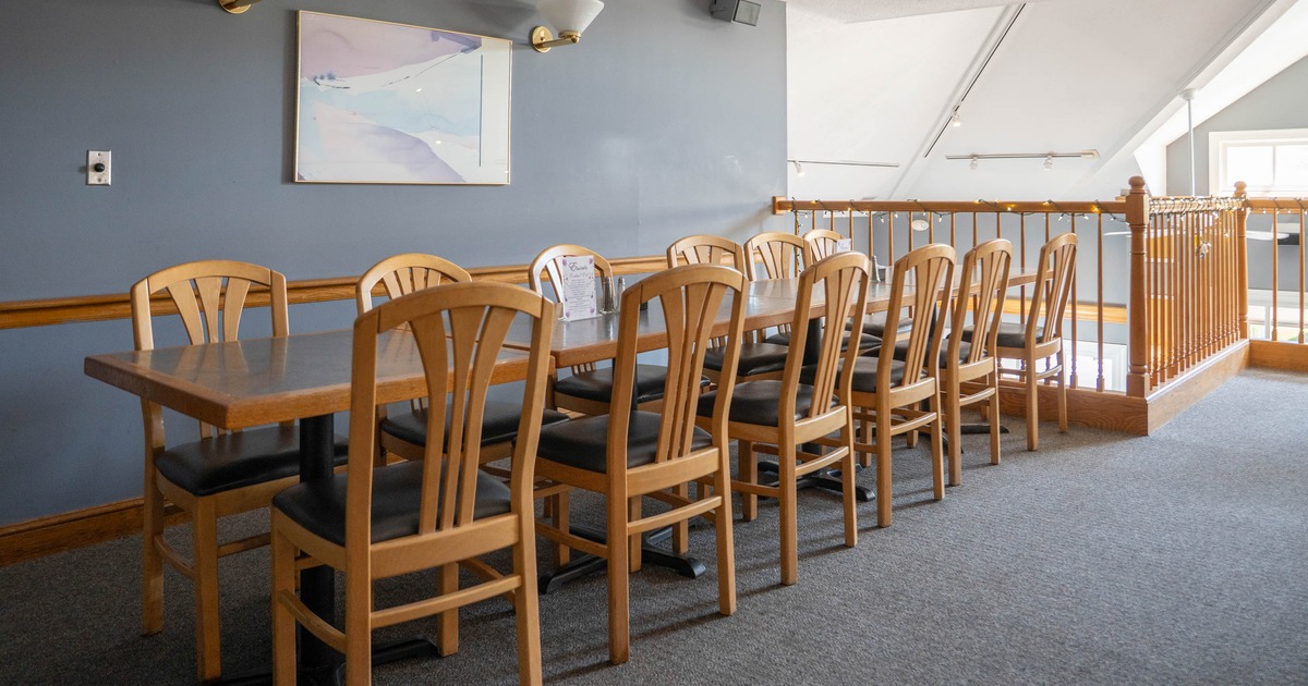 Long wooden table with chairs in a gray-walled room