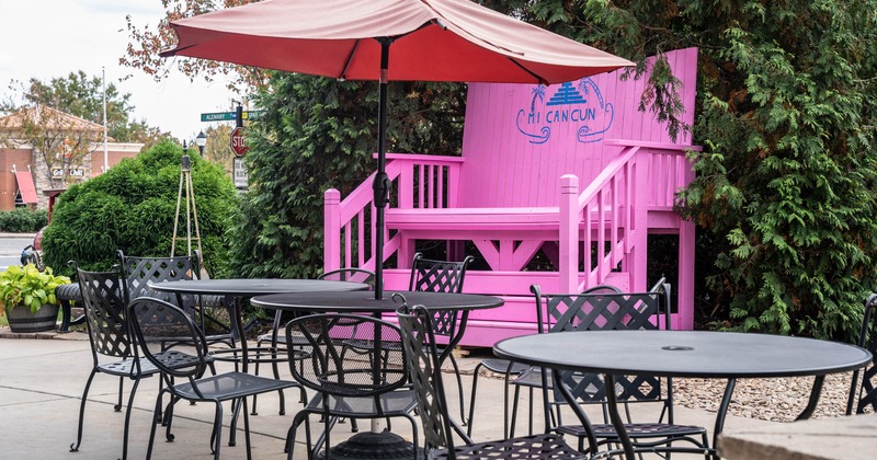 Exterior, partially covered seating area, parasols, metal tables and chairs