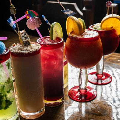 Assorted cocktail drinks displayed on a bar counter.