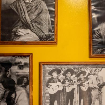 Black-and-white photos on a yellow wall.