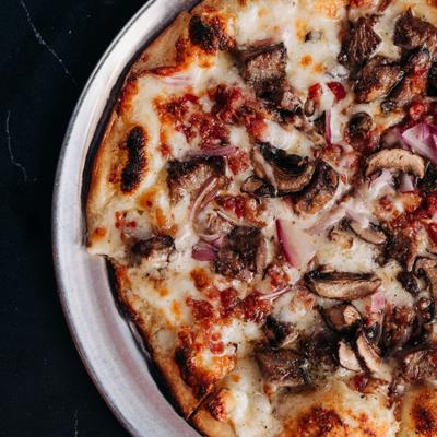 The Gio pizza with beef, bacon, mushrooms, and mozzarella, closeup.