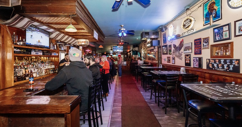 Interior, guests at the bar area, bar tables and stools