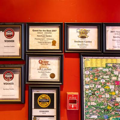 Wall display of framed awards and certificates.
