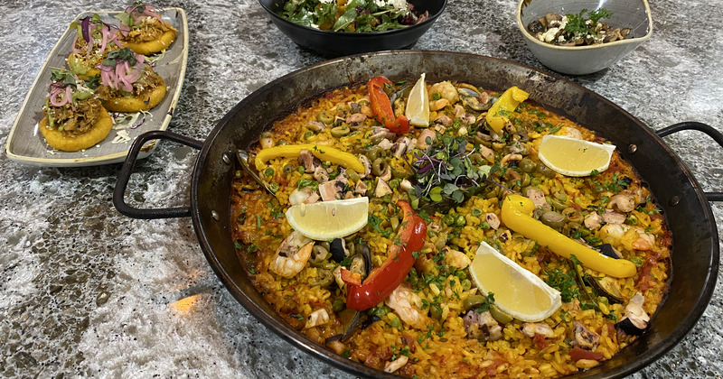 shrimp paella with fresh papers and lemons on top