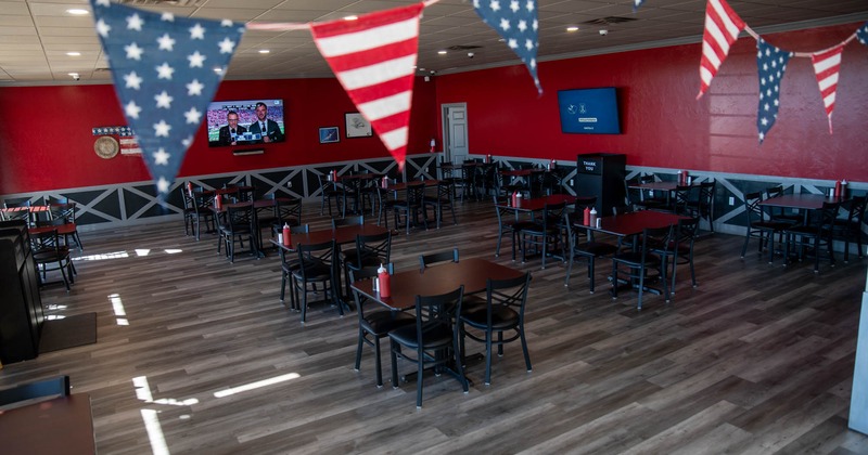 Dining area, tables ready for guests, TVs on the walls