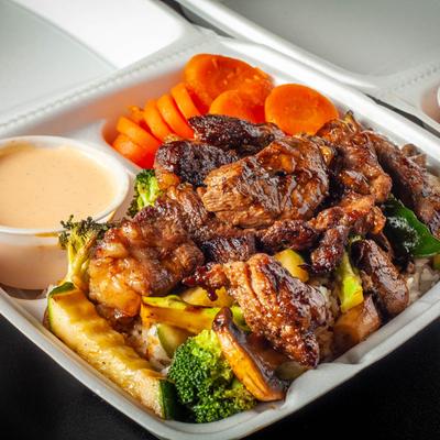 Rib eye tray with a side of sweet carrots and yaki sauce