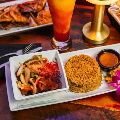 Succulent Fried Pork with rice and sauce, served with a layered cocktail.