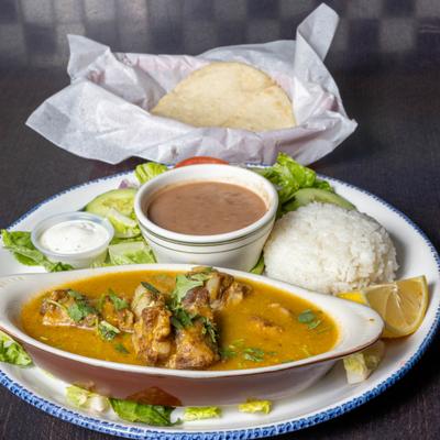 Pork ribs in green salsa sauce, served with salad, rice, beans, and tortillas.