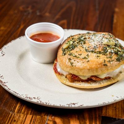 Garlic knot chicken parmesan sandwich and dipping sauce.