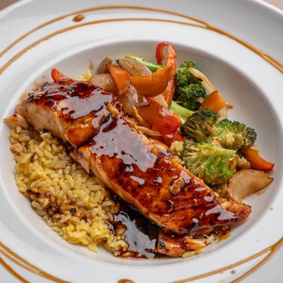 Glazed salmon served with rice and vegetables.