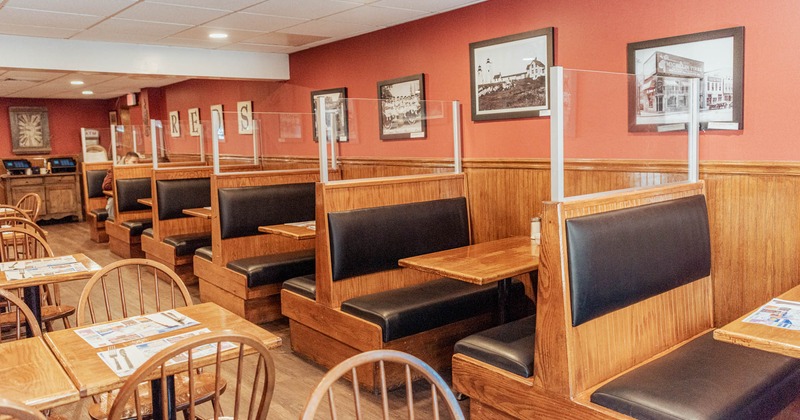 Booths and tables with chairs inside, photos on the wall