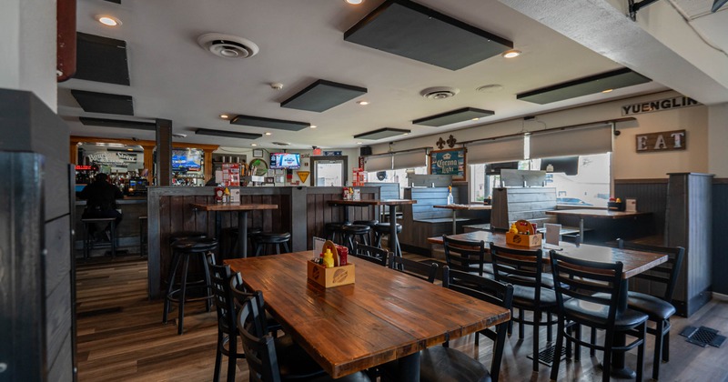 Interior, seating and dining area, tables with chairs, wooden booths in the back