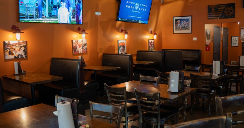 Interior with booth and standard seating, wall art, and two TVs