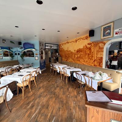Seafood restaurant dining room with a mural, white tablecloths, and sailfish decor.