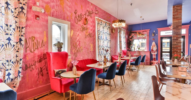 Interior, lounge area,  tables with various types of chairs, floral pattern curtains, entrance