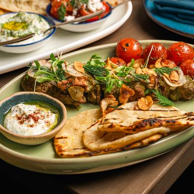 Lamb Sirloin Kebab with green chermoula, bread, roasted cherry tomatoes and a dip.
