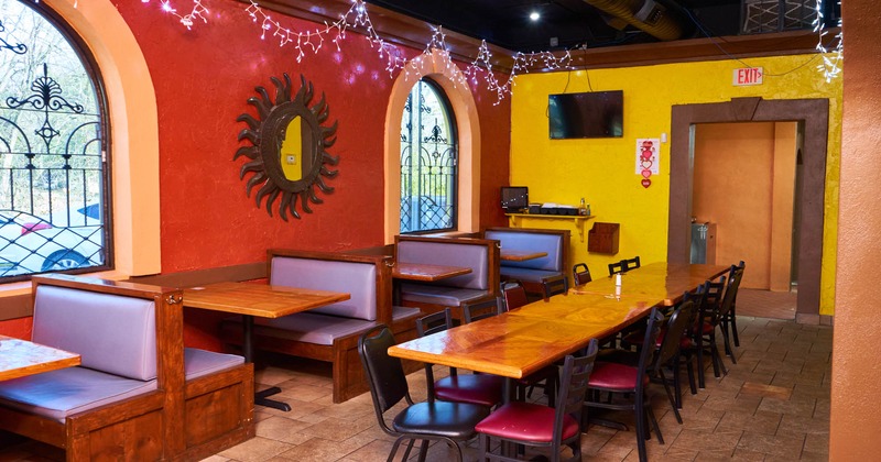 Interior, tables and chairs, benches with leather cushion and back lined up next to the window