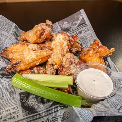 Garlic Parmesan Wings served with a dip and celery sticks.