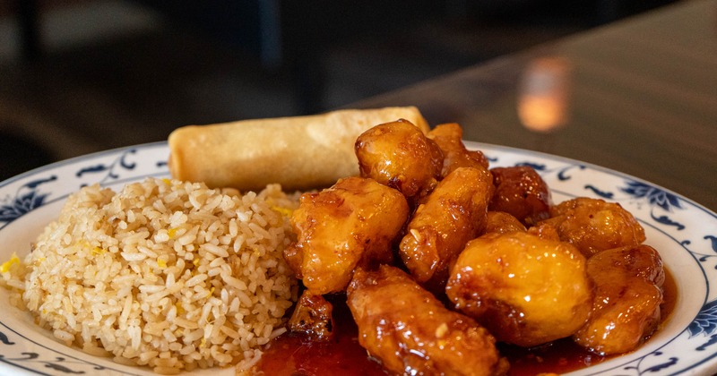 General Tso's chicken served with a side or rice and a spring roll
