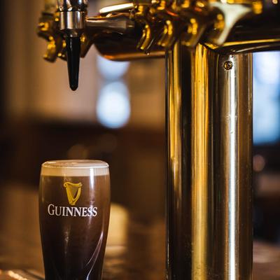 A beer dispensary with a full dark beer glass labeled 