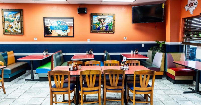 Interior with colorful  leather booths, orange walls  with decor and art