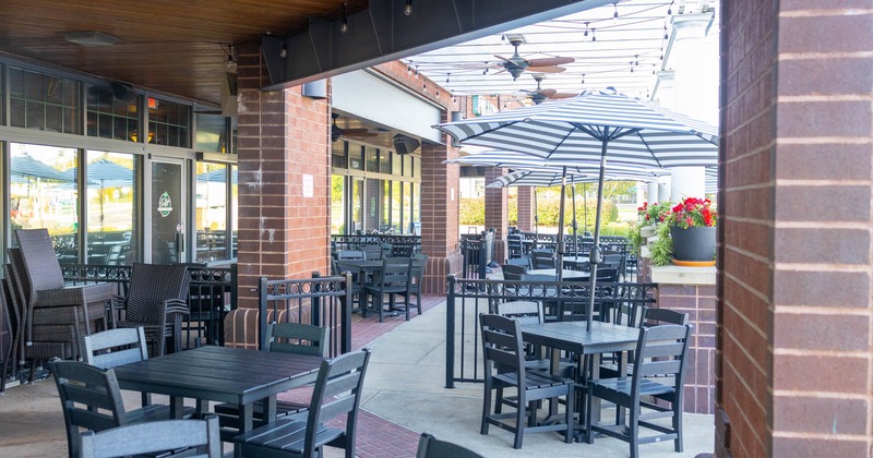 Exterior, covered seating area, tables with chairs, parasols, ceiling lanterns